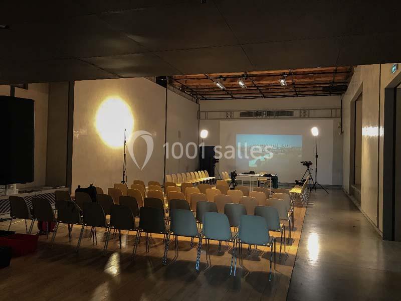 Location salle Avignon (Vaucluse) - Le Grenier à Sel #5 Salle de conférence vide avec des rangées de chaises, un projecteur allumé et un écran affichant une image.