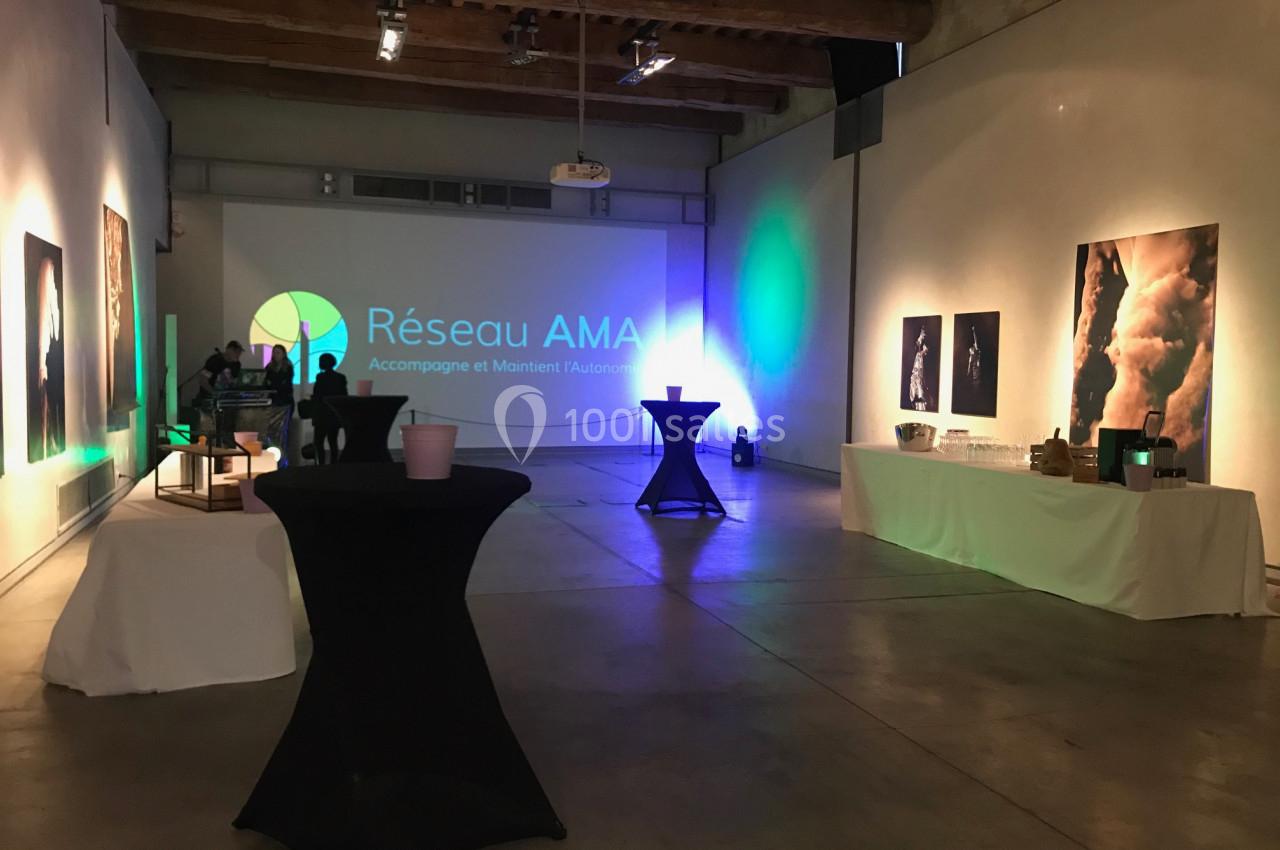 Location salle Avignon (Vaucluse) - Le Grenier à Sel #11 Salle d'exposition avec des œuvres accrochées aux murs, tables hautes et projection lumineuse ’Réseau AMA’.