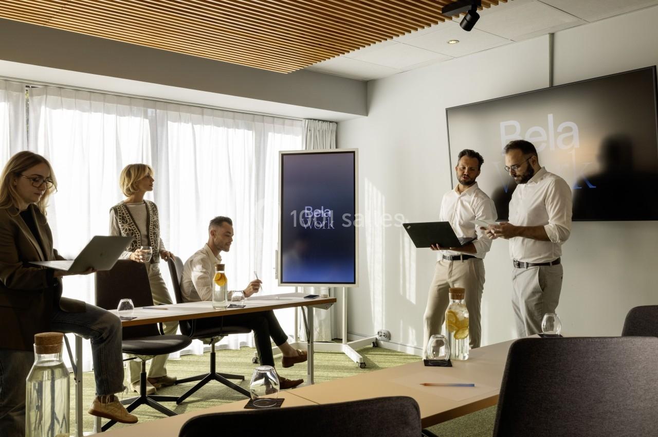 Location salle Montpellier (Hérault) - Hôtel Belaroïa #13 Un groupe de personnes travaille dans une salle de réunion lumineuse avec des écrans affichant ’Bela Work’.