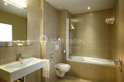 Une femme assise devant des machines à sous dans un casino, regardant l'écran de jeu.