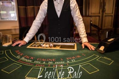 Miniature Location salle Salies-de-Béarn (Pyrénées-Atlantiques) - Casino-Hôtel du Parc Salies-de-béarn #22 Croupier debout derrière une table de blackjack dans un casino, avec jetons et cartes visibles.