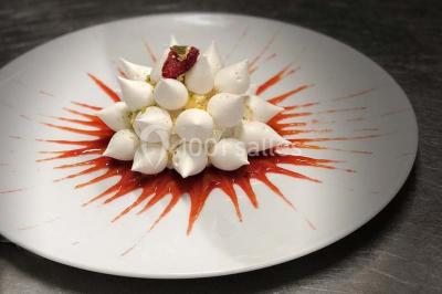 Salle de restaurant élégante avec tables dressées, chaises en bois sculpté et décor floral sur les murs et le sol.