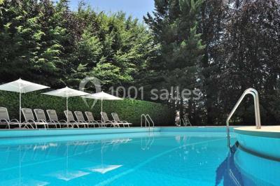 Salle de restaurant élégante avec tables dressées, chaises en bois sculpté et décor floral sur les murs et le sol.