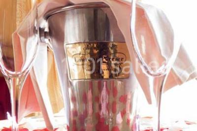 Salle de restaurant élégante avec tables dressées, chaises en bois sculpté et décor floral sur les murs et le sol.