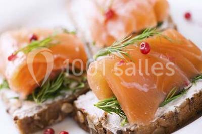 Salle de restaurant élégante avec tables dressées, chaises en bois sculpté et décor floral sur les murs et le sol.