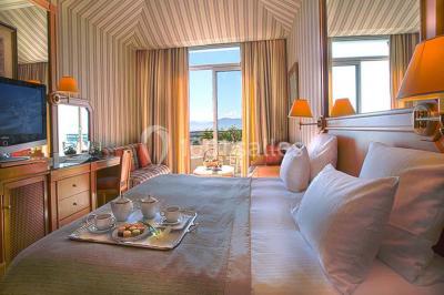 Salle de restaurant élégante avec tables dressées, chaises en bois sculpté et décor floral sur les murs et le sol.