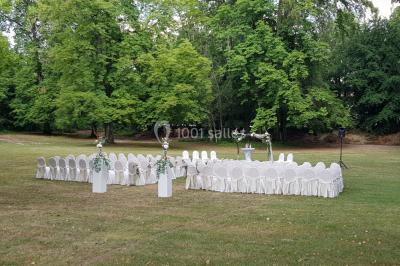 Salle de restaurant élégante avec tables dressées, chaises en bois sculpté et décor floral sur les murs et le sol.