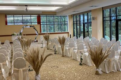 Salle de restaurant élégante avec tables dressées, chaises en bois sculpté et décor floral sur les murs et le sol.
