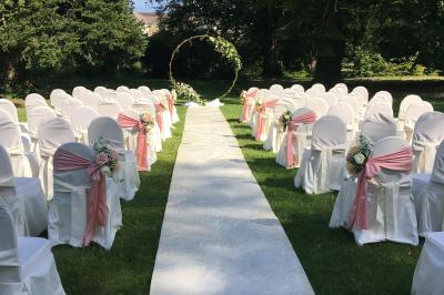 Salle de restaurant élégante avec tables dressées, chaises en bois sculpté et décor floral sur les murs et le sol.