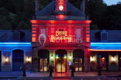 Salle de réception avec scène, piste de danse en bois, moquette rouge et plafond décoré d'une fresque.