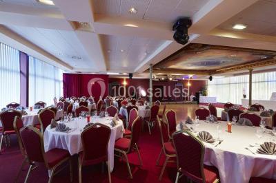 Salle de réception avec scène, piste de danse en bois, moquette rouge et plafond décoré d'une fresque.