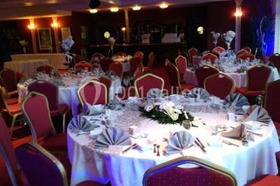 Salle de réception avec scène, piste de danse en bois, moquette rouge et plafond décoré d'une fresque.