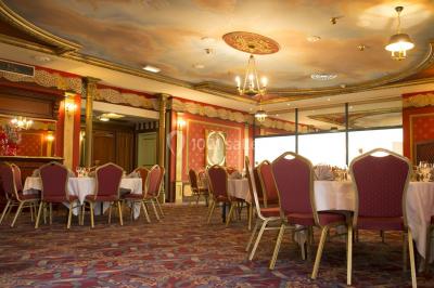 Salle de réception avec scène, piste de danse en bois, moquette rouge et plafond décoré d'une fresque.