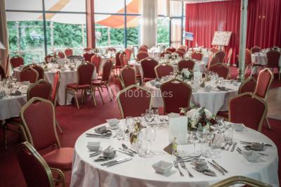 Salle de réception avec scène, piste de danse en bois, moquette rouge et plafond décoré d'une fresque.