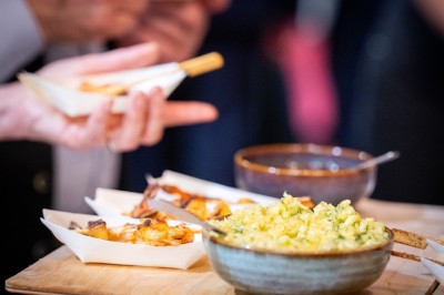 Un barman réalise un spectacle de flair bartending avec des verres et un shaker dans une salle éclairée.