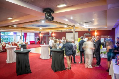 Un barman réalise un spectacle de flair bartending avec des verres et un shaker dans une salle éclairée.
