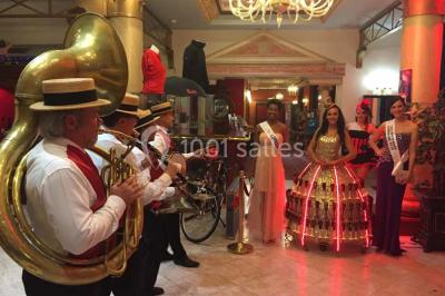 Miniature Accueil en fanfare Un barman réalise un spectacle de flair bartending avec des verres et un shaker dans une salle éclairée.