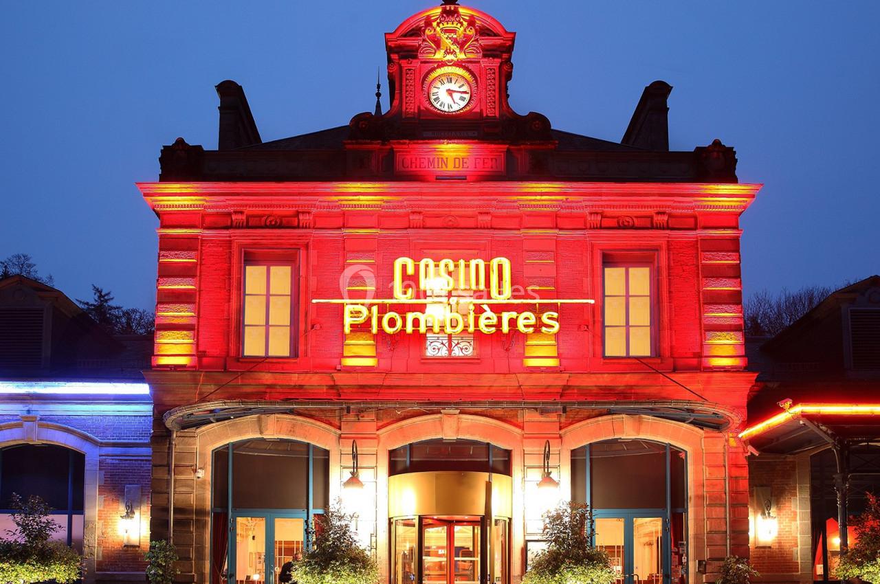 L'ancienne gare, by night Façade illuminée du casino de Plombières-les-Bains avec horloge centrale et enseigne lumineuse.