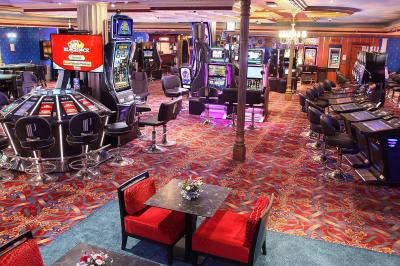 Miniature L'espace jeux avec le Black Jack et la Roulette Anglaise électroniques Un barman réalise un spectacle de flair bartending avec des verres et un shaker dans une salle éclairée.
