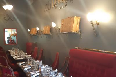 Miniature Le quai au Restaurant, idéal en petits groupes Un barman réalise un spectacle de flair bartending avec des verres et un shaker dans une salle éclairée.
