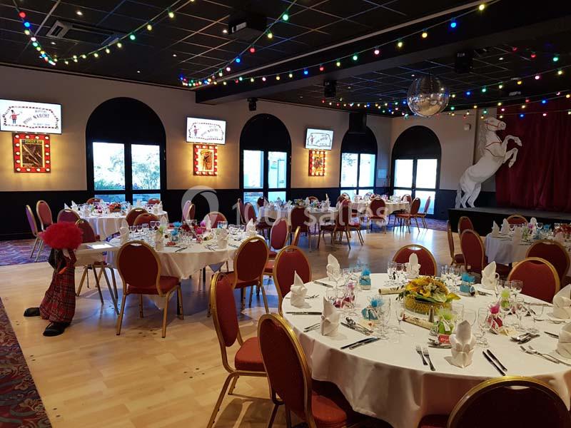 Location salle Saint-Galmier (Loire) - Casino de Saint-Galmier #3 Salle de réception décorée avec des tables dressées, des guirlandes lumineuses et une scène avec un cheval blanc.