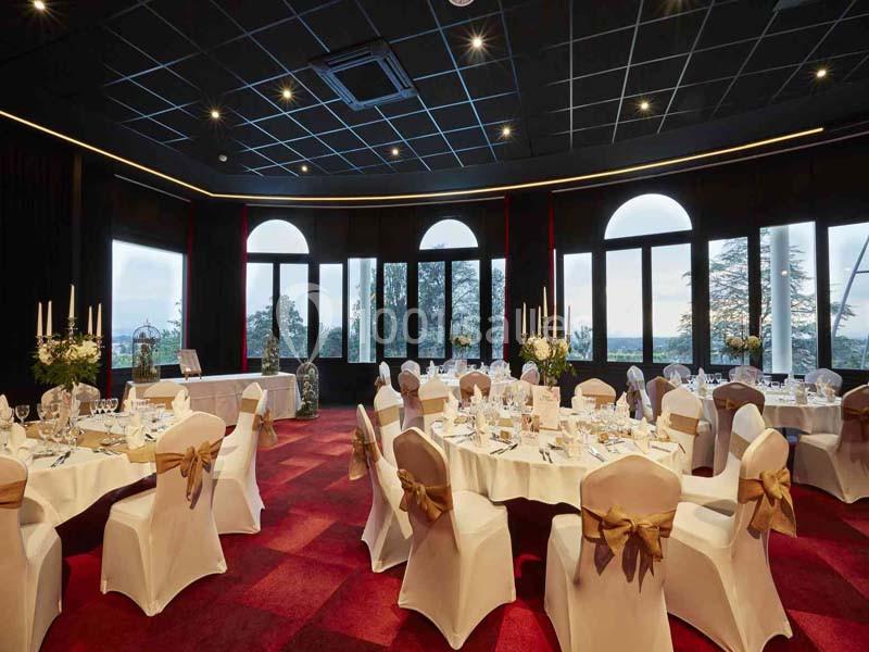 Location salle Saint-Galmier (Loire) - Casino de Saint-Galmier #4 Salle de réception élégante avec tables rondes décorées, nappes blanches et grandes baies vitrées donnant sur l'extérieur.