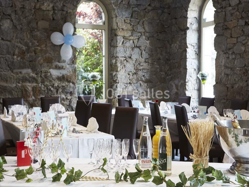 Location salle Saint-Galmier (Loire) - Casino de Saint-Galmier #6 Salle en pierre avec tables dressées pour un événement, décorée de ballons et de feuillage, lumière naturelle entrant par…