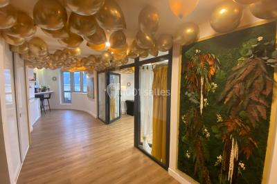 Miniature Location salle Paris 8 (Paris) - L'Appart Terrasse des Champs #12 Salle lumineuse avec parquet, plafond décoré de ballons dorés, table avec plantes et vue sur des bâtiments urbains.