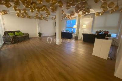 Miniature Location salle Paris 8 (Paris) - L'Appart Terrasse des Champs #5 Salle lumineuse avec parquet, plafond décoré de ballons dorés, table avec plantes et vue sur des bâtiments urbains.