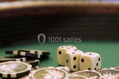 Miniature Location salle Paris 17 (Paris) - Club 3-5-7 #16 Des jetons de casino et deux dés blancs posés sur une table de jeu verte.