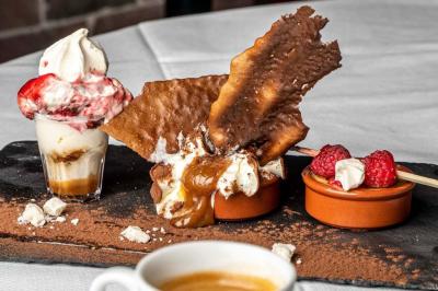 Deux voitures de luxe, une sportive grise et un SUV gris foncé, stationnées côte à côte en extérieur de nuit.