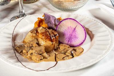 Deux voitures de luxe, une sportive grise et un SUV gris foncé, stationnées côte à côte en extérieur de nuit.