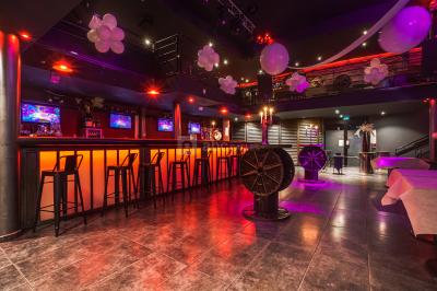 Deux voitures de luxe, une sportive grise et un SUV gris foncé, stationnées côte à côte en extérieur de nuit.