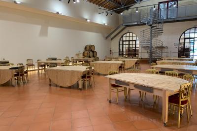 Une voiture bleue traverse un chemin bordé de vignes et de murets en pierre sous un ciel dégagé.