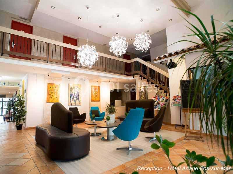 Salon lumineux avec fauteuils modernes, canapé courbé, tables basses et lustres design dans un espace d'accueil spacieux.