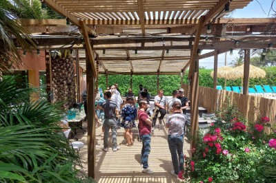 Miniature Location salle Hyères (Var) - La Réserve Hyères - Giens #31 Des personnes dansent en couple sur une piste éclairée par des lumières colorées, tandis que d'autres sont assises autour.