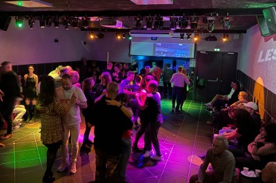 Miniature Location salle Hyères (Var) - La Réserve Hyères - Giens #36 Des personnes dansent en couple sur une piste éclairée par des lumières colorées, tandis que d'autres sont assises autour.