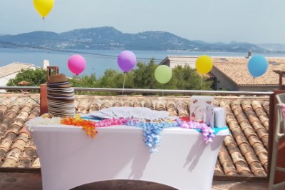 Miniature Anniversaire sur le Rooftop Des personnes dansent en couple sur une piste éclairée par des lumières colorées, tandis que d'autres sont assises autour.
