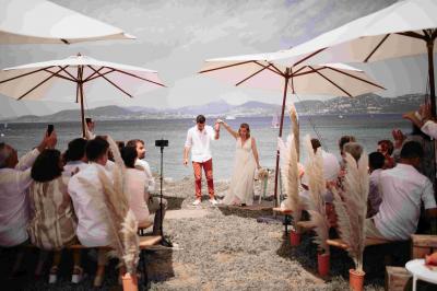 Miniature Cérémonie laïque sur le terrain Les Pieds dans l'Eau Des personnes dansent en couple sur une piste éclairée par des lumières colorées, tandis que d'autres sont assises autour.