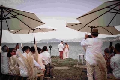 Miniature Cérémonie laïque sur le terrain Les Pieds dans l'Eau Des personnes dansent en couple sur une piste éclairée par des lumières colorées, tandis que d'autres sont assises autour.