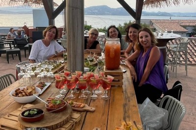 Miniature EVJF sur le Rooftop Des personnes dansent en couple sur une piste éclairée par des lumières colorées, tandis que d'autres sont assises autour.