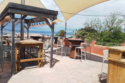 Miniature Rooftop vue mer Des personnes dansent en couple sur une piste éclairée par des lumières colorées, tandis que d'autres sont assises autour.