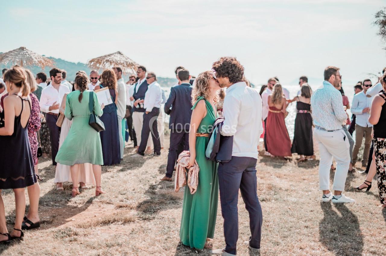 Groupe de personnes en tenue élégante discutant en extérieur lors d'un événement sous un ciel dégagé.