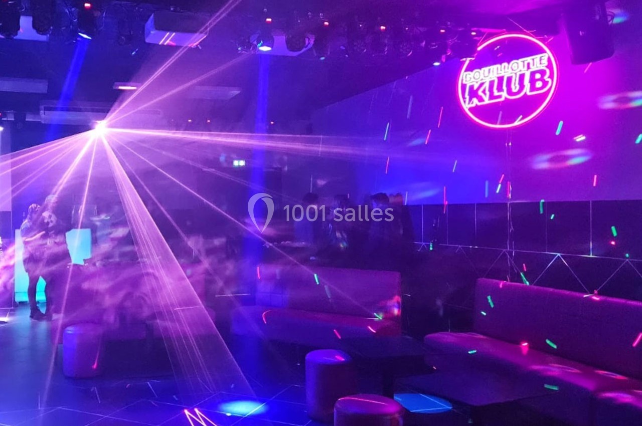 Location salle Hyères (Var) - La Réserve Hyères - Giens #10 Salle de discothèque avec jeux de lumières colorées, néons et quelques personnes autour de tables basses.