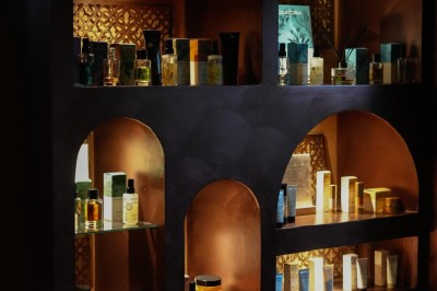 Miniature Aphrodite SPA Salle de massage tamisée avec deux tables recouvertes de draps bruns et une décoration murale apaisante.