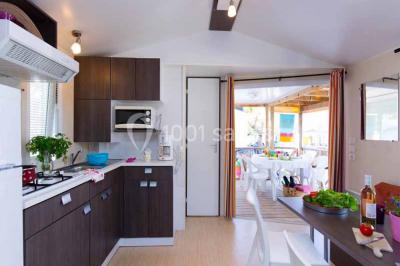 Miniature Mobil-home Salle de massage tamisée avec deux tables recouvertes de draps bruns et une décoration murale apaisante.