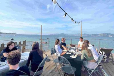 Miniature Pointe Panoramique Salle de massage tamisée avec deux tables recouvertes de draps bruns et une décoration murale apaisante.