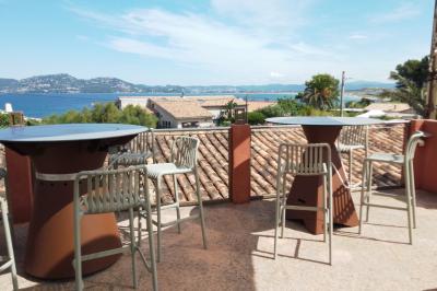 Miniature Rooftop vue mer Salle de massage tamisée avec deux tables recouvertes de draps bruns et une décoration murale apaisante.