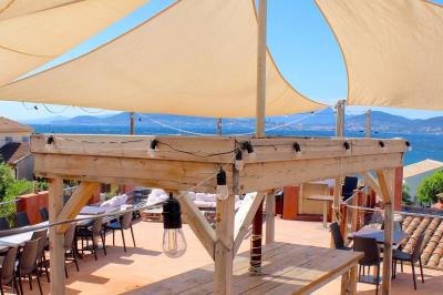 Miniature Rooftop vue mer Salle de massage tamisée avec deux tables recouvertes de draps bruns et une décoration murale apaisante.