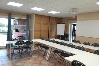 Miniature Salle Madrague Salle de massage tamisée avec deux tables recouvertes de draps bruns et une décoration murale apaisante.